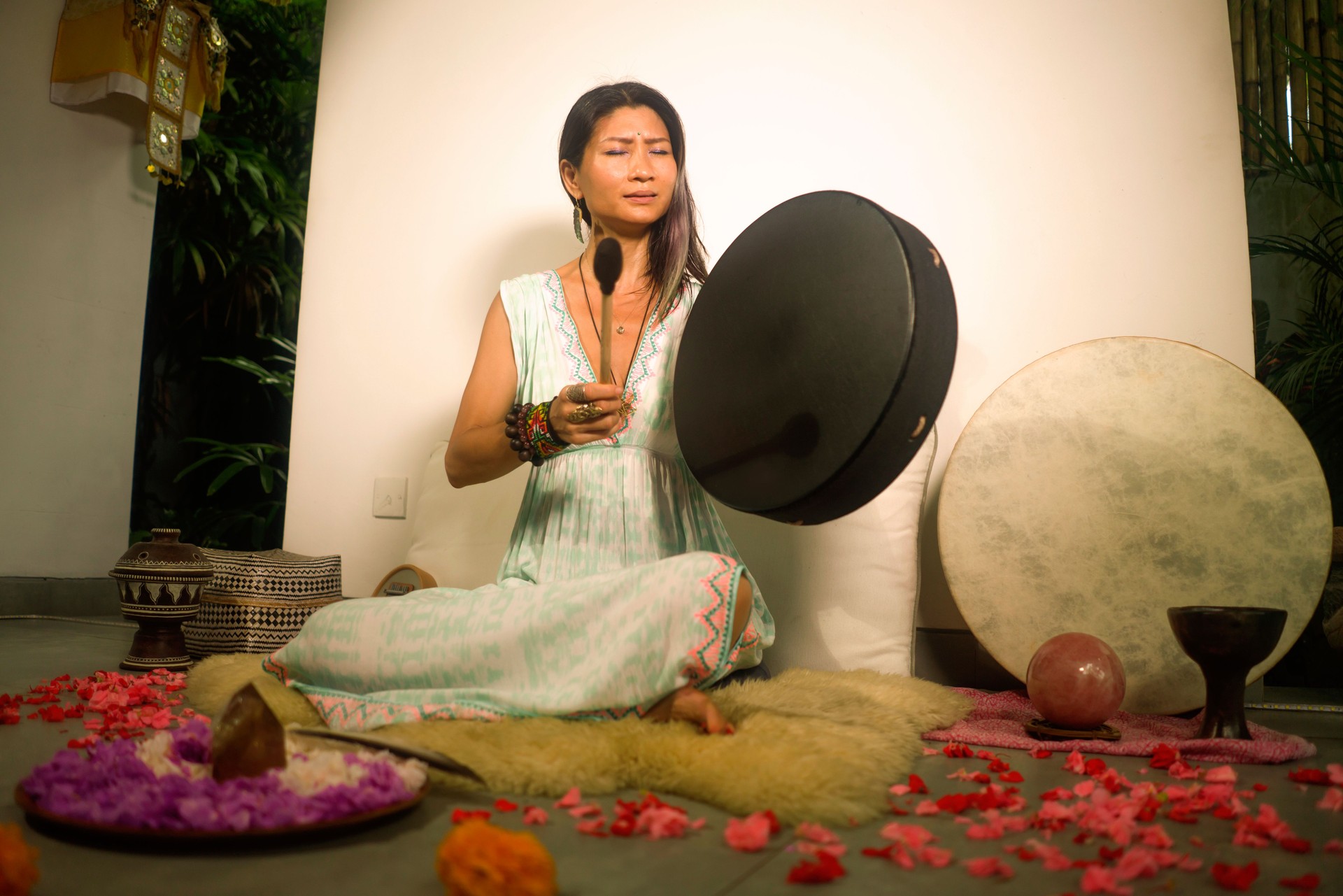 sound healing and meditation therapy - attractive and elegant Asian Chinese healer woman playing drum at yoga studio as relaxation exercise in wellness and healthy lifestyle