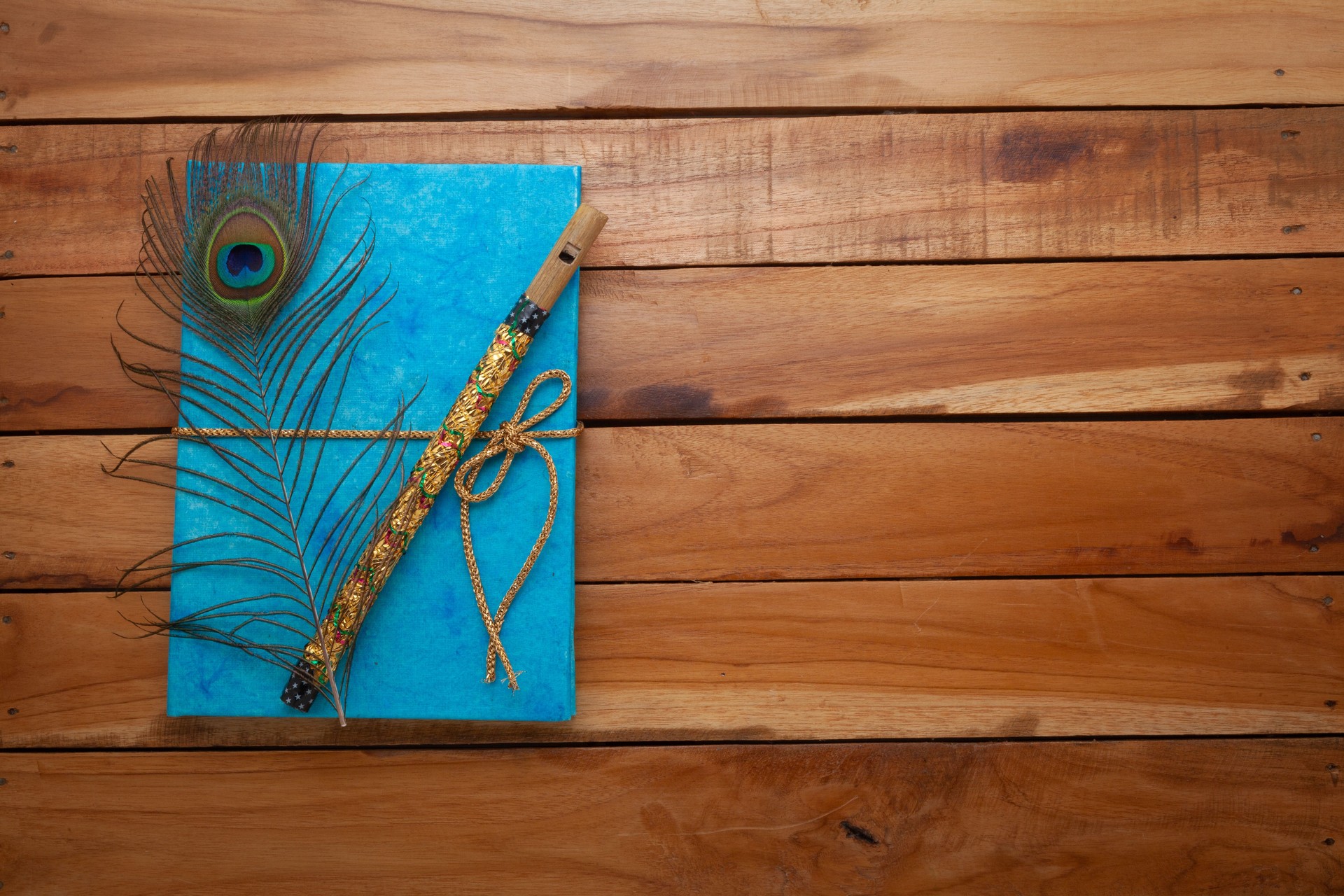 Beautiful Blue colored textured Diary made with handmade paper, Peacock feather and a flute on the top.