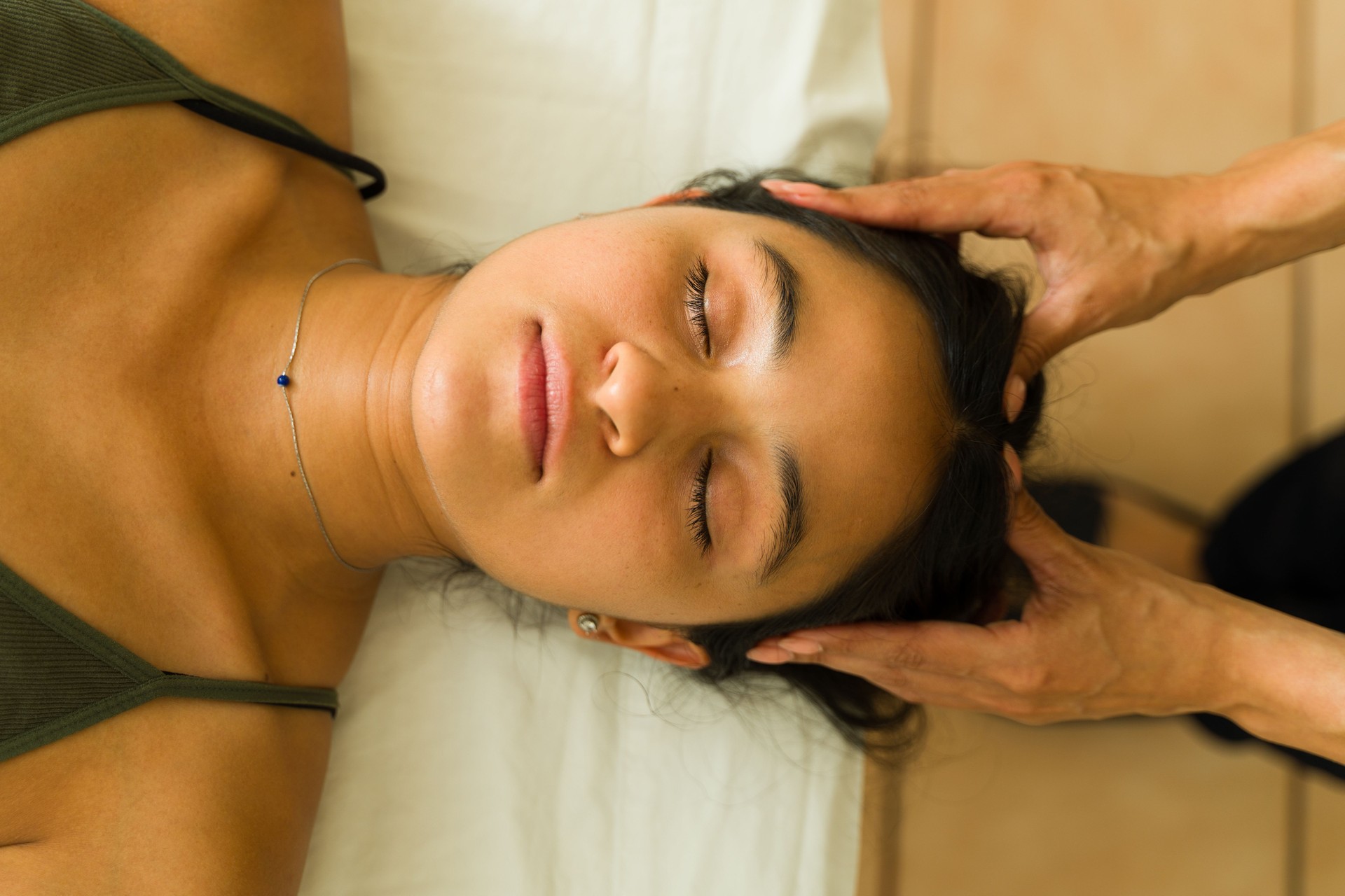 Hispanic woman relaxing during reiki energy therapy